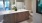 Large well lit bathroom with large mirror and brown cabinets 